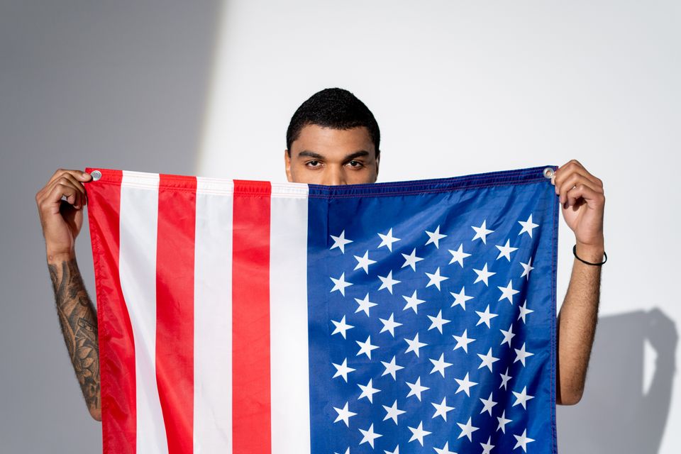 Man holding an American flag representing how to stay sane in America