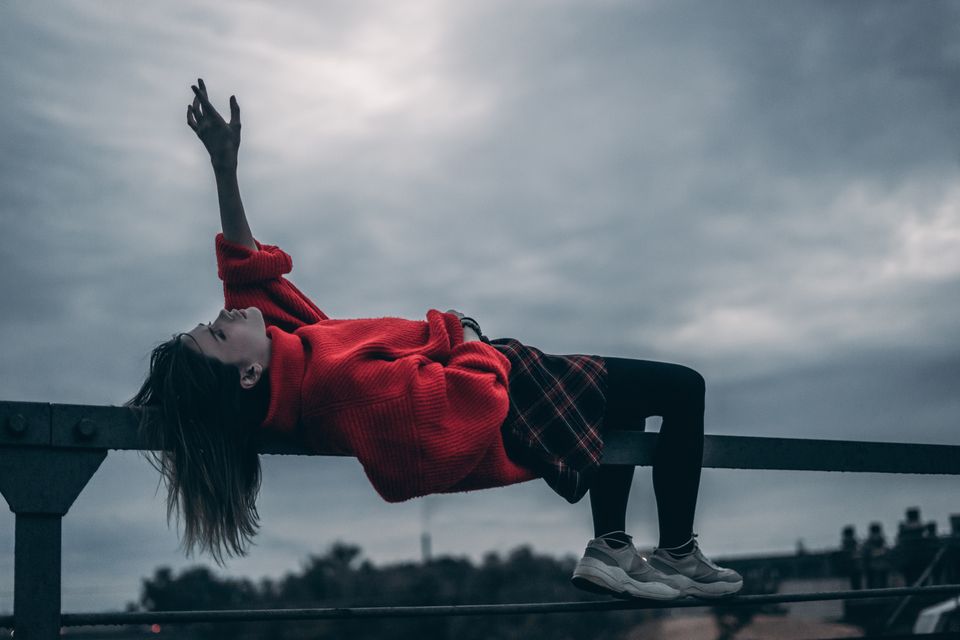 Sad woman reaching to the sky trying to overcome her inner critic