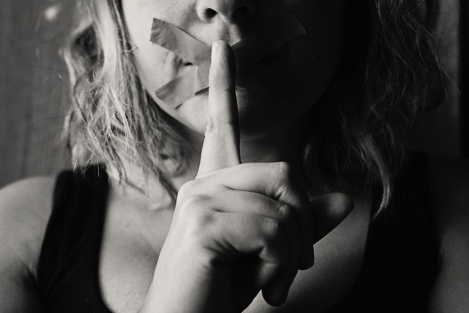 Woman with her index finger over her mouth representing social anxiety