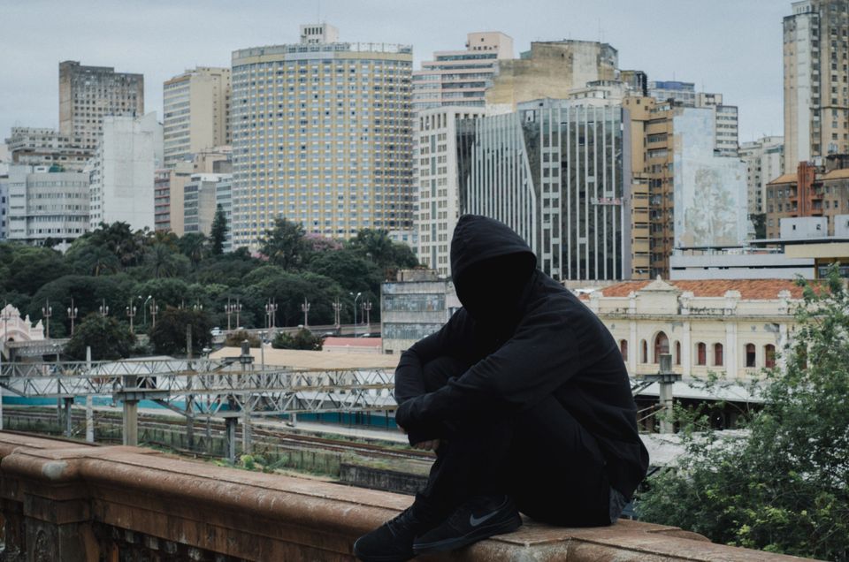 A sad man in a dark hoodie representing not feeling worthy of success