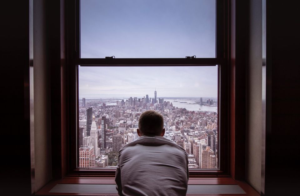 man looking out a window representing using your subconscious to handle your problems