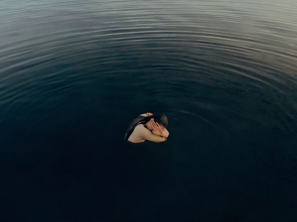 Woman in a dark lake representing struggling with and beating depression