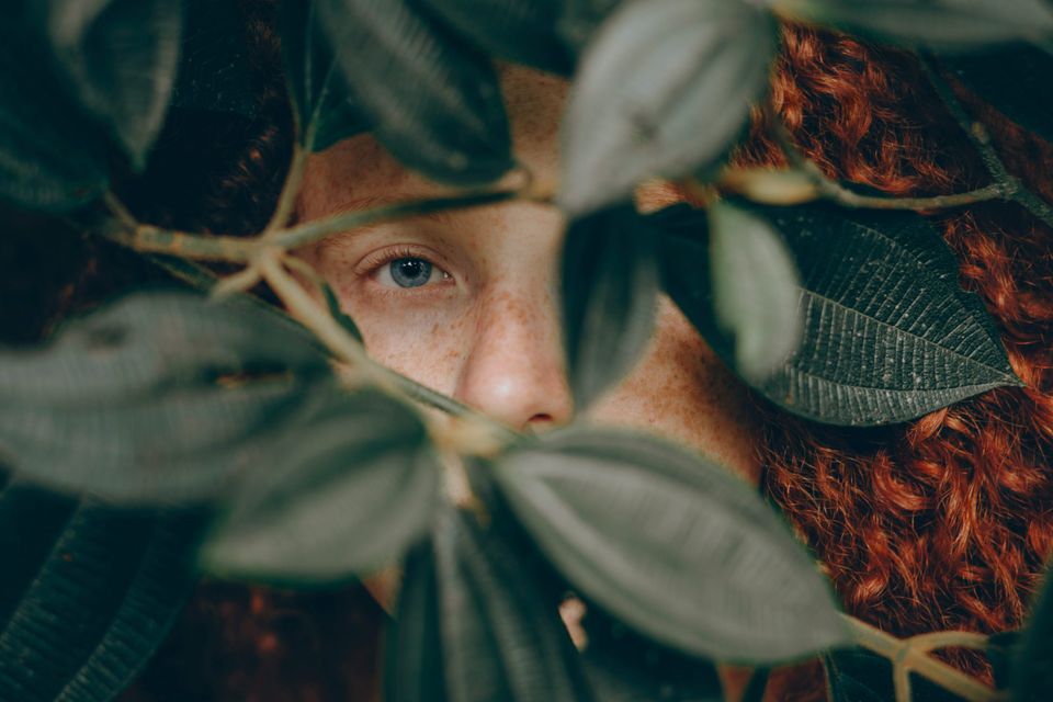 Woman in a bush representing hiding from feeling better