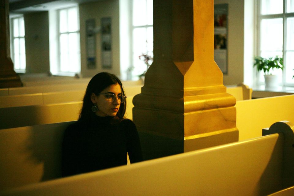 Sad woman in a church pew realizing it's time for a serious change